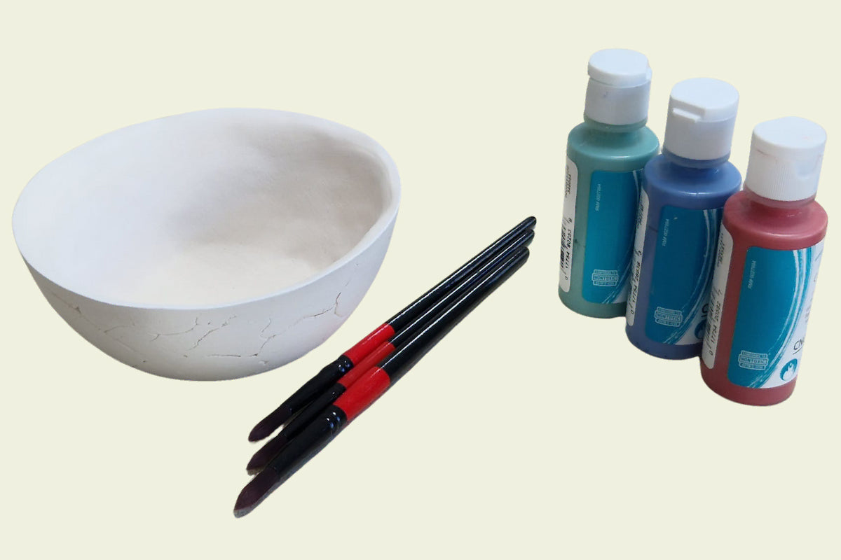 Keraminis dubuo su įrankiais, skirtais glazūravimui ir dažymui.