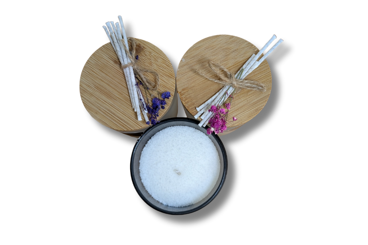 Rankų darbo smėlio vaško žvakės baltame ir juodame stikliniame inde.