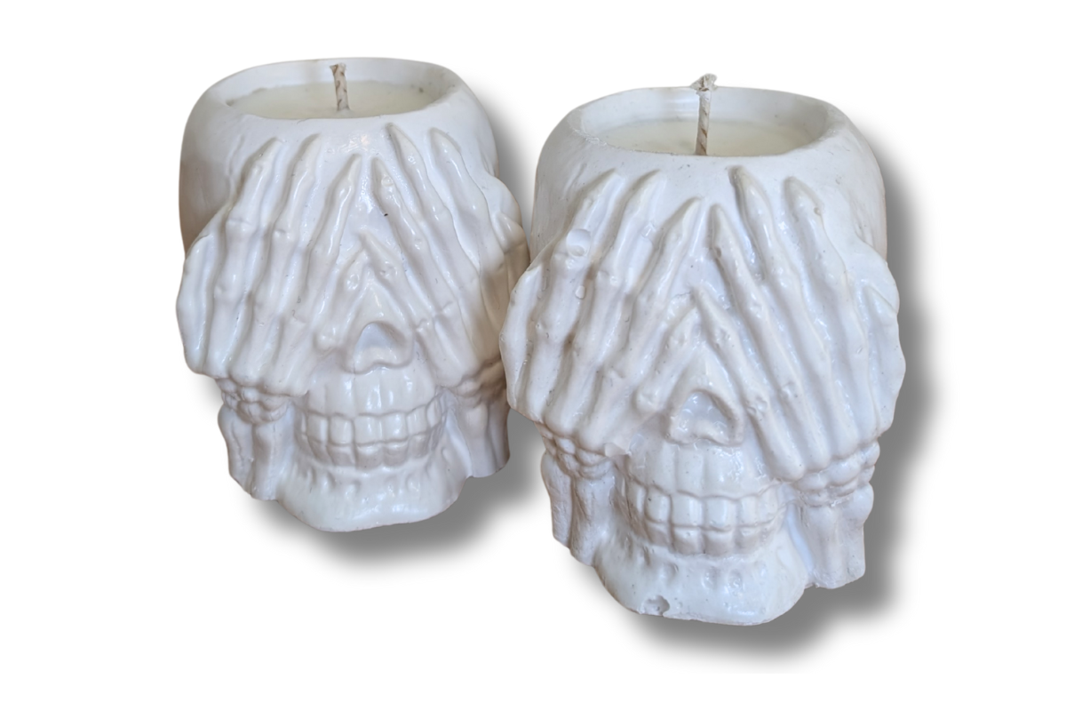 Dvi baltos kaukolės formos žvakės su detalėmis