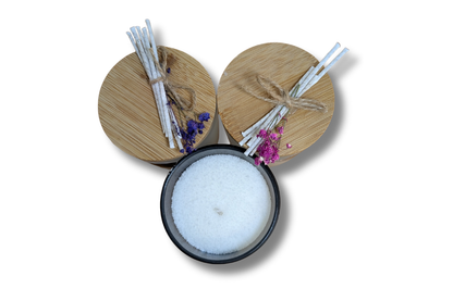 Rankų darbo smėlio vaško žvakės baltame ir juodame stikliniame inde.